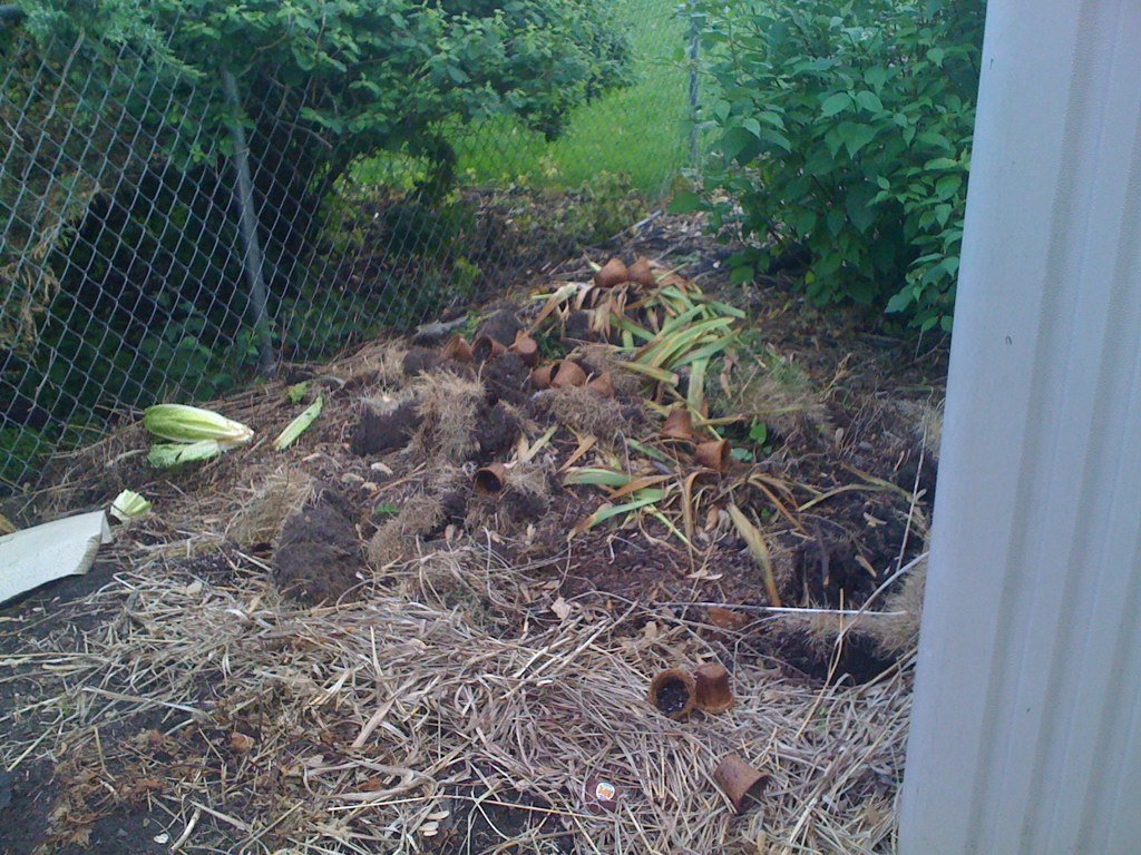 Compost et déchets de jardin mélangés pour vérifier l’humidité et relancer la décomposition.