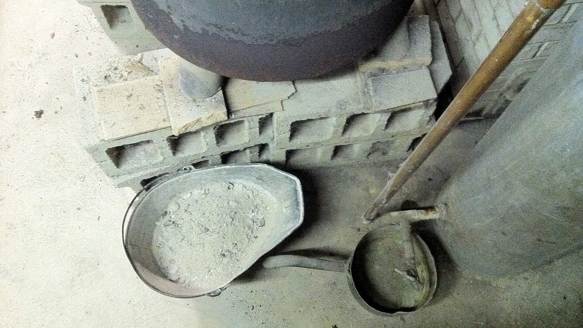 Cendres de bois froides près d’un composteur dans un jardin écologique