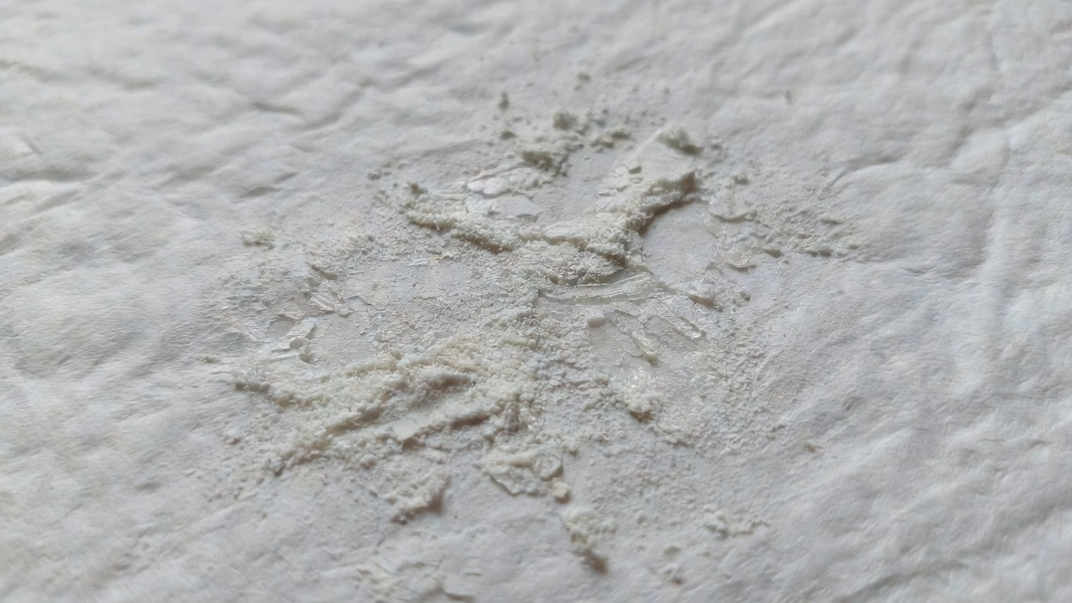 Poudre blanche sur un essuie-tout, sans pile ni marque visible.